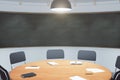 College classroom with round wooden table and blackboard