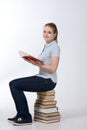 College female student sitting on stack books Royalty Free Stock Photo