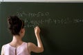 college female student writing on blackboard completing mathematical equations Royalty Free Stock Photo