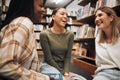 College friends, library and together to study while talking about book, research and knowledge from education and Royalty Free Stock Photo