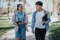 College friends walking and talking in a campus park with notebooks Royalty Free Stock Photo