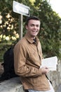 College Student with Book Smiling Outside