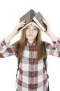 College student bored, frustrated and overwhelmed. Young girl with a backpack on his back holding books over her head Royalty Free Stock Photo