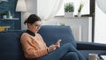 College student browsing internet on smartphone at home Royalty Free Stock Photo