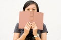 College student covering her face with book Royalty Free Stock Photo