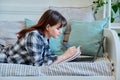 College student girl studying at home, lying on couch with a lap Royalty Free Stock Photo