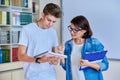 College student guy teenager meeting discussing with teacher mentor in classroom Royalty Free Stock Photo