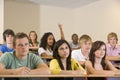 College student with hand raised in lecture