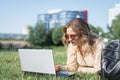 College student lying down on the grass working on laptop Royalty Free Stock Photo