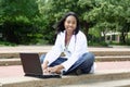 Beautiful female African American college student on campus wearing whitecoat Royalty Free Stock Photo