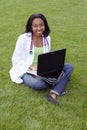 Beautiful female African American college student on campus wearing whitecoat Royalty Free Stock Photo