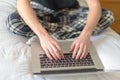 College student sitting on bed working on laptop Royalty Free Stock Photo