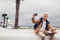 College student sitting on bench by sea taking selfie and holding book on Langeron beach in Odessa Royalty Free Stock Photo