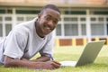 College student using laptop on campus lawn Royalty Free Stock Photo