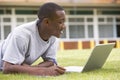 College student using laptop on campus lawn Royalty Free Stock Photo