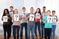 College students holding question mark signs