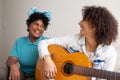 College students playing guitar and singing together in small apartment at living room. Fun and happy times Royalty Free Stock Photo