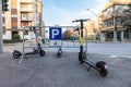 Collegno, Italy. February 15th, 2021. Group of electric kick scooters parked on a sidewalk. Gathering station with parking sign