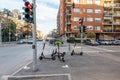 Collegno, Italy. February 15th, 2021. Group of electric kick scooters parked on a sidewalk near a traffic light. Gathering station