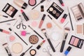 Makeup cosmetics such as eyeshadows, lipstick, mascara and makeup accessories on white, wooden background, top view