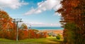 inviting landscape view from the mountain with open air gondolas,cars going down on sunny autumn day, Georgian Bay, Lake Huron