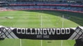 Collingwood Magpies supporter scarf with blurred background view of Melbourne Cricket Ground field during a footy game