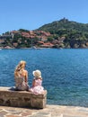 Woman and girl sitting on a stone wall by the harbor in Collioure, France Royalty Free Stock Photo