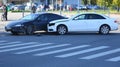 Collision of a black car and a white car at a pedestrian crossing