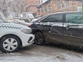 he collision of a white taxi and a black car due to ice.
