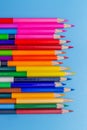 Collor wooden pencils in row isolated on bluebackground.