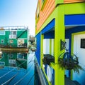 Colorful village of float homes on bright sunny day, blue sky.