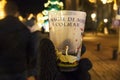 COLMAR, FRANCE - DECEMBER 29, 2017: Christmas glasses for hot mulled wine in the hands of a tourist against the background of the