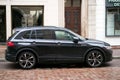 Profile view of black volkswagen tiguan SUV car parked in the street by rainy day