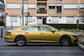 Profile view of ocher Volkswagen art eon parked in the street