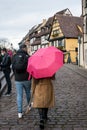 Couple walking in the street with a pink umbrella