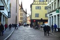 People walking along the old street with traditional medieval houses. Colmar, France.