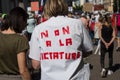 Woman protesting with text on shirt in french, non a la dictature, in English, no dictatorship