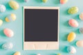 Coloeful easter eggs and instant photo on pastel color background with space. Royalty Free Stock Photo
