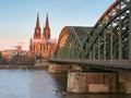 Cologne Cathedral in the rays of the rising sun and the Hohenzollern Bridge over the river Rhine in the German city Royalty Free Stock Photo