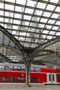 COLOGNE, GERMANY - April 7 2018: Rear view of Cologne railway station with red train. Cathedral tower on background