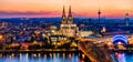 Beautiful night landscape of the gothic Cologne cathedral, Hohenzollern Bridge and the River Rhine at sunset and blue hour in Royalty Free Stock Photo