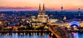 Beautiful night landscape of the gothic Cologne cathedral, Hohenzollern Bridge and the River Rhine at sunset and blue hour in Royalty Free Stock Photo