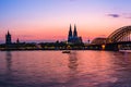 Evening silhouette skyline landscape of the gothic Cologne Cathedra, Hohenzollern railway and pedestrian bridge, the old town and