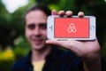 COLOGNE, GERMANY - May 06, 2018: Closeup of young man holding white iPhone with AIRBNB LOGO on screen Royalty Free Stock Photo