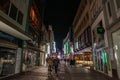 COLOGNE, GERMANY - NOVEMBER 5, 2022: Selective blur on a crowd of people walking on Hohe Strasse street at night, with shops & Royalty Free Stock Photo