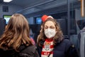 COLOGNE, GERMANY - NOVEMBER 12, 2022: Selective blur on a woman with glasses wearing a facemask in a train in Koln with a cologne
