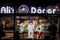 COLOGNE, GERMANY - NOVEMBER 11, 2022: Selective blur on youngsters with Cologne Carnival costume in a kebab fast food restaurant