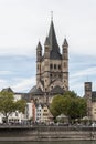 COLOGNE, GERMANY - SEPTEMBER 11, 2016: Colorful houses in Bavarian style and the Romanesque Catholic church `Gross Sankt Martin`