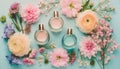 Cologne and perfume bottles surrounded by flowers seen from above in pastel colors on a turquoise background. Royalty Free Stock Photo