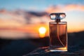 Cologne and perfumery. Close up of glass golden perfume bottle standing on a beach. Defocused twilight sunset at the Royalty Free Stock Photo